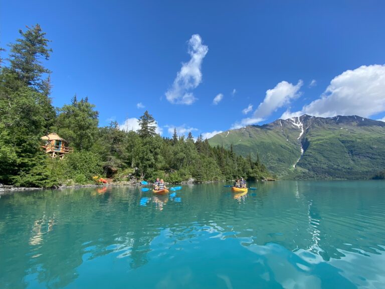 Kayakers on pristine glacial water in front of Secluded Grant Lake Backcountry Camp near Moose Pass, Alaska